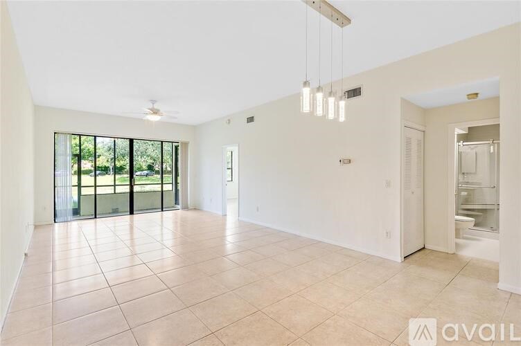 A spacious room with tiled flooring and a ceiling fan.