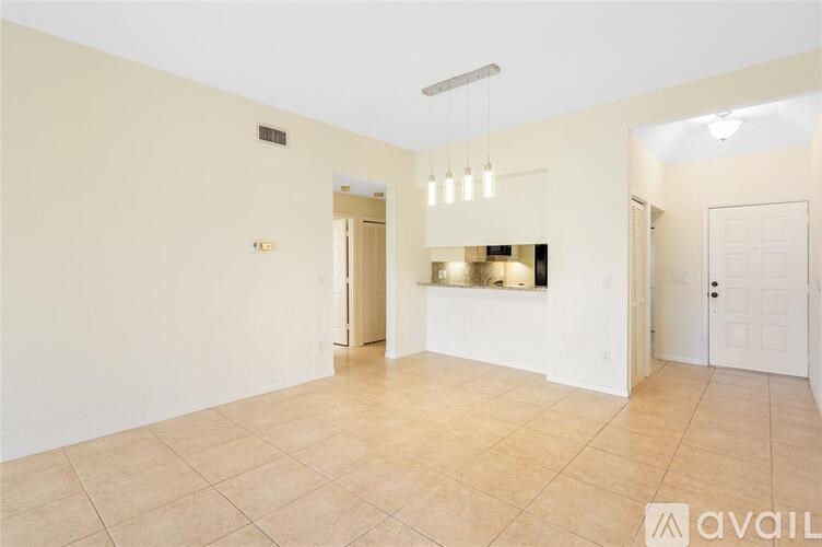 A spacious room with tiled flooring and white walls.