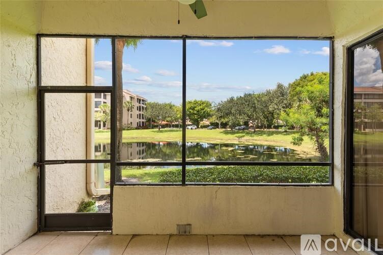 A balcony with a view of a green park and buildings.