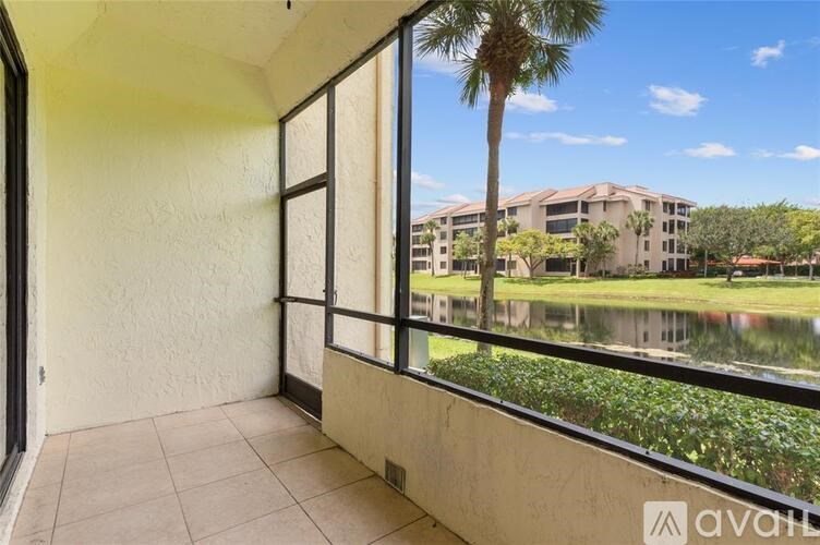 A balcony with a view of a building and a palm tree.
