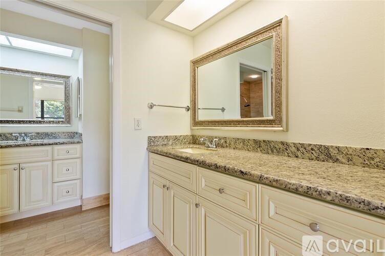 A bathroom with a marble countertop and a large mirror.