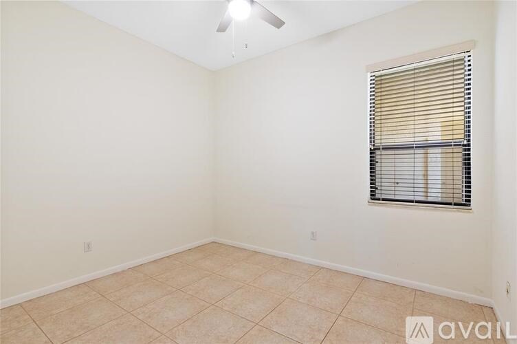 A room with a window covered by blinds and a ceiling fan.