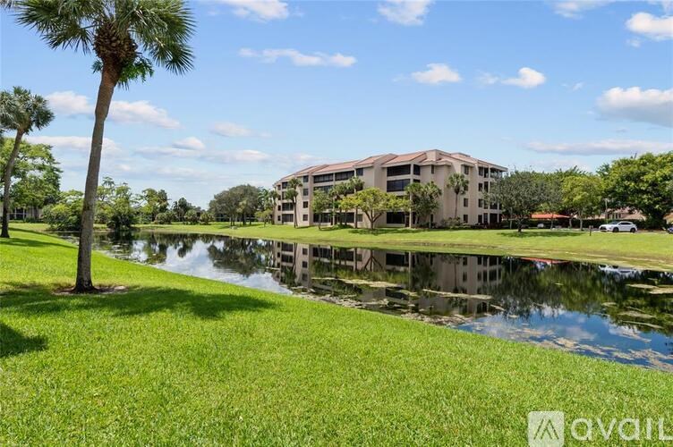 A building is reflected in the water of a pond.