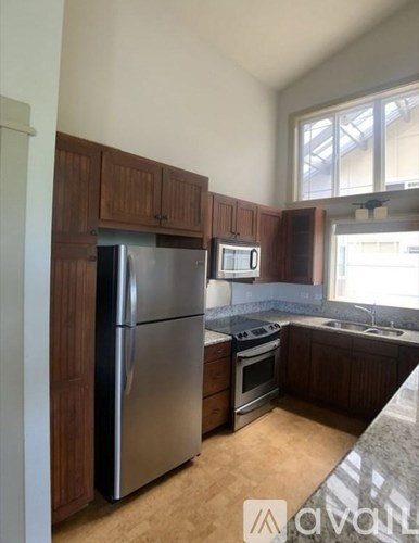 A kitchen with a stainless steel refrigerator and microwave.