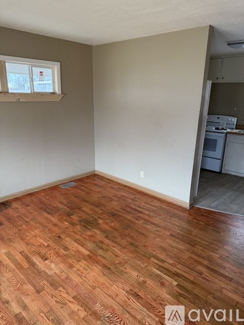 A room with wooden flooring and a window.