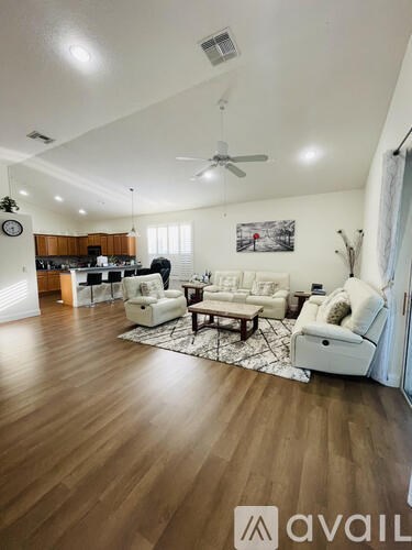 A living room with a white couch and a wooden floor.