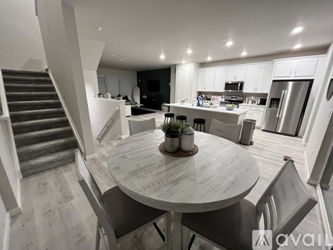 A modern kitchen with a dining table and chairs in the foreground.
