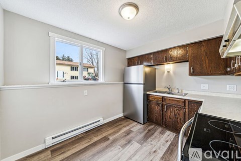 A kitchen with a refrigerator, sink, and cabinets.