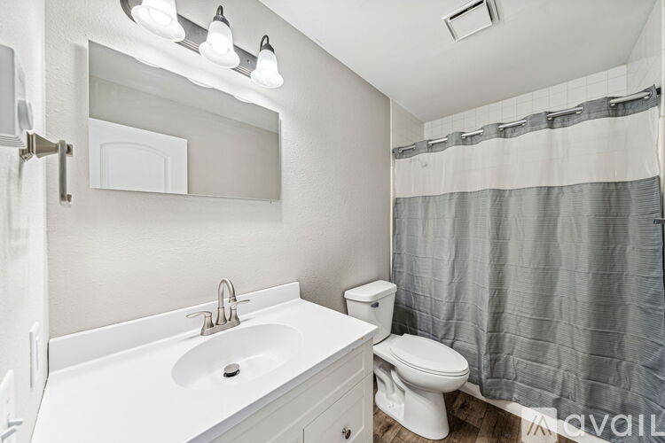 A white bathroom with a toilet, sink, and shower.