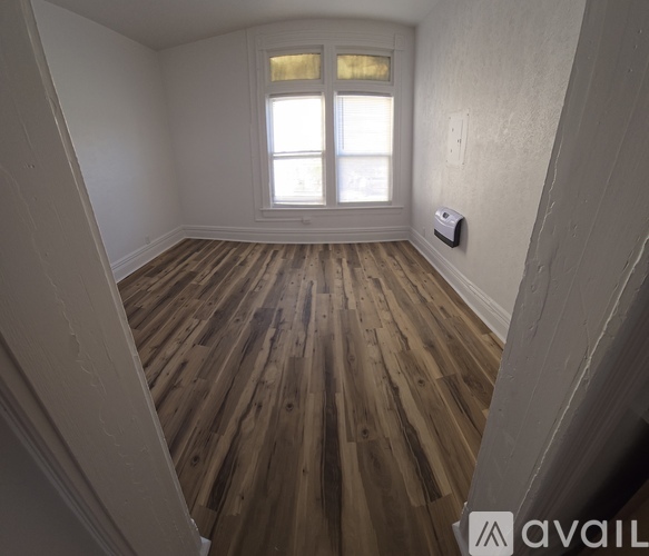 A room with wooden flooring and a window.