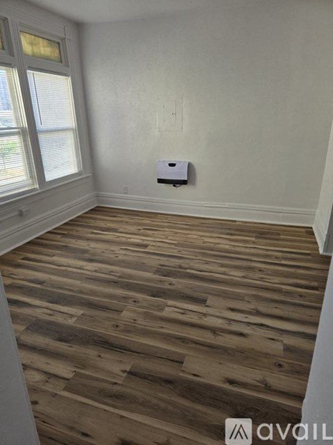 A room with wooden flooring and a window.