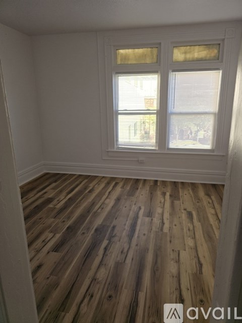 A room with wooden flooring and a window.