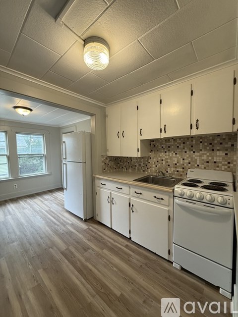 A kitchen with white appliances and cabinets.