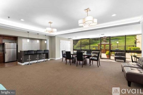 A spacious living room with a kitchen area in the background.