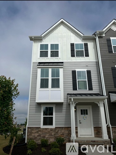 A two-story house with a white door and windows.