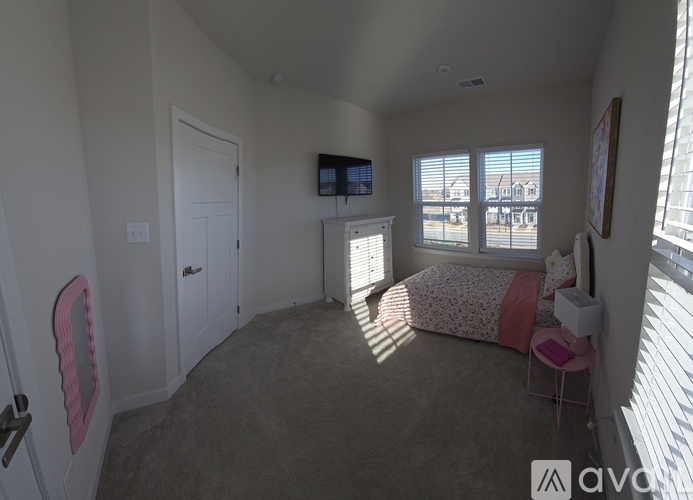 A bedroom with a bed, chair, and television.