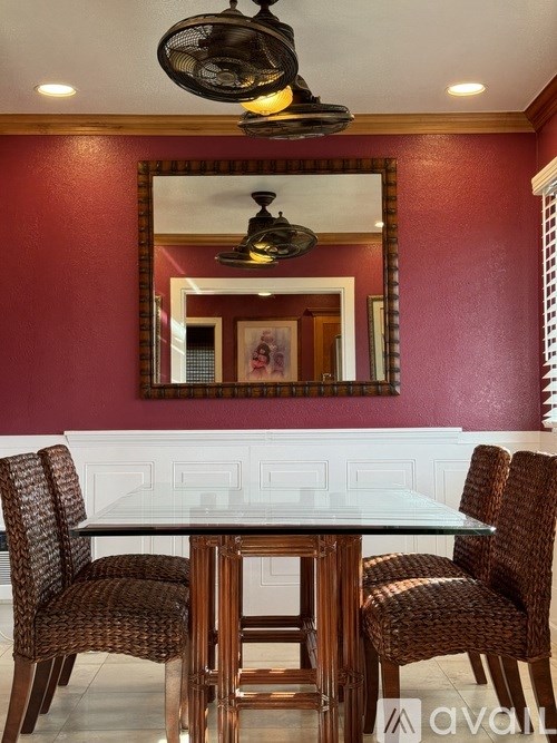 A dining room with a table and chairs.