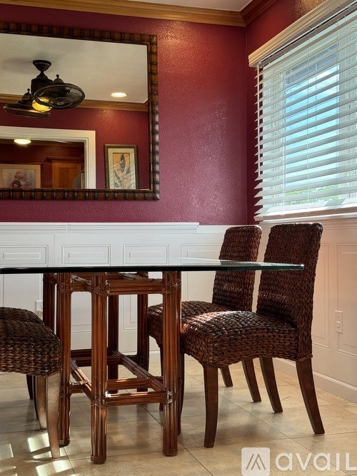 A dining room with a glass table and chairs.