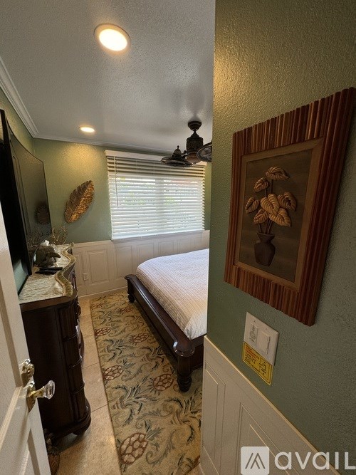 A bedroom with a large bed and a mirror above it.