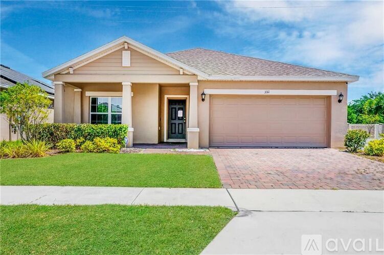 A house with a garage door and a driveway in front.