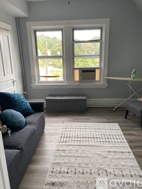 A living room with a grey couch and a large window.