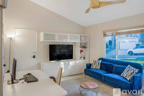 A living room with a blue couch and a television.