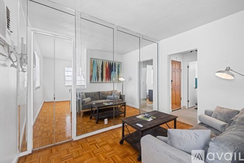 A living room with a grey couch and a coffee table in front of a glass wall.