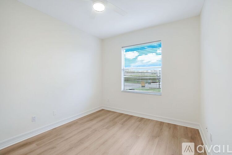 A room with a window and wooden flooring is available for rent.