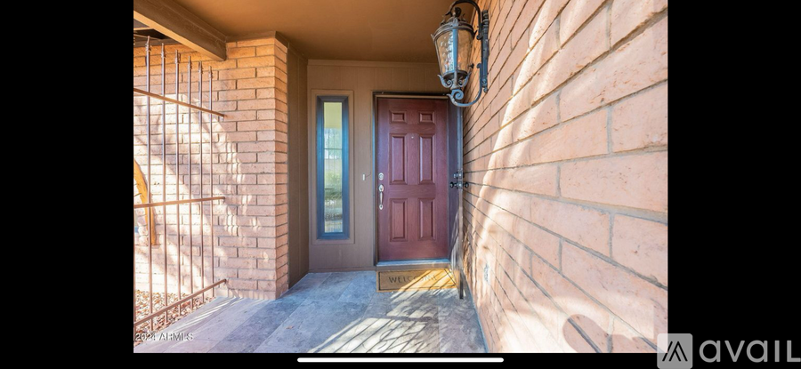 A red door is on the right side of a brick wall.