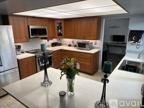 A kitchen with a table in the middle and a vase of flowers on it.