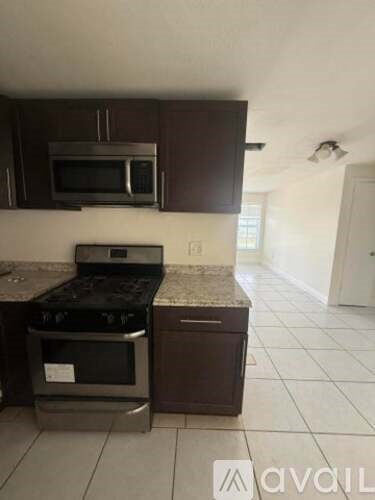 A kitchen with a stove top oven and microwave above it.