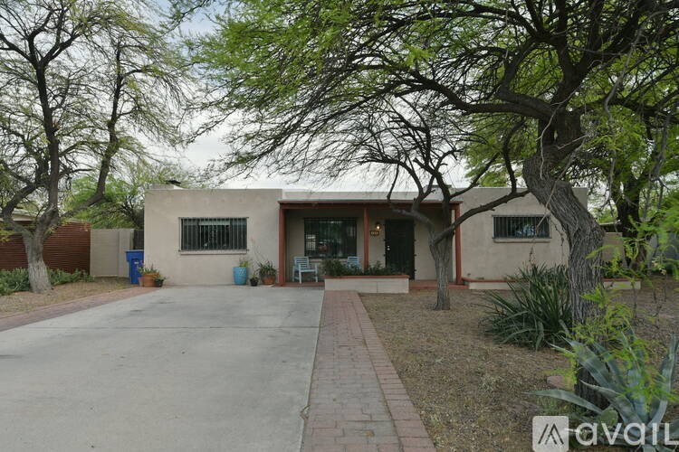 A house with a driveway and trees in front.