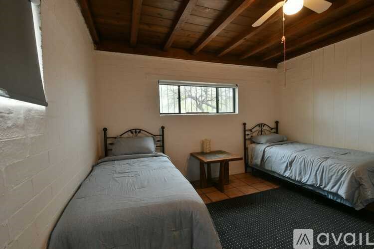 A bedroom with two beds and a ceiling fan.