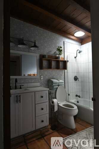 A bathroom with a toilet, sink, and shower.