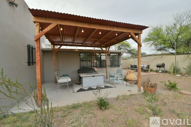 A covered patio area with a couch and chairs.