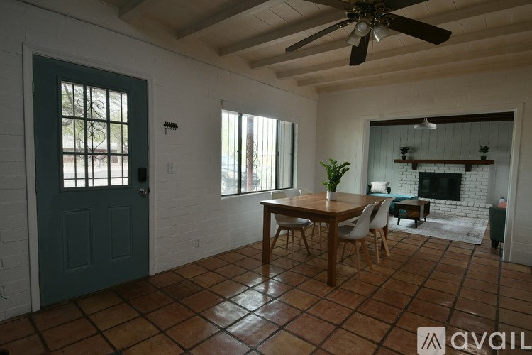 A room with a table and chairs and a ceiling fan.