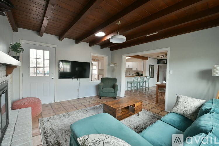 A living room with a couch, a chair, a table, and a television.