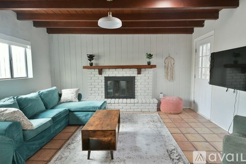 A living room with a green couch and a fireplace.