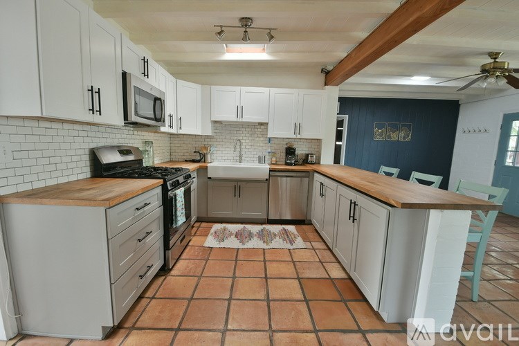 A kitchen with white cabinets and a tile floor.