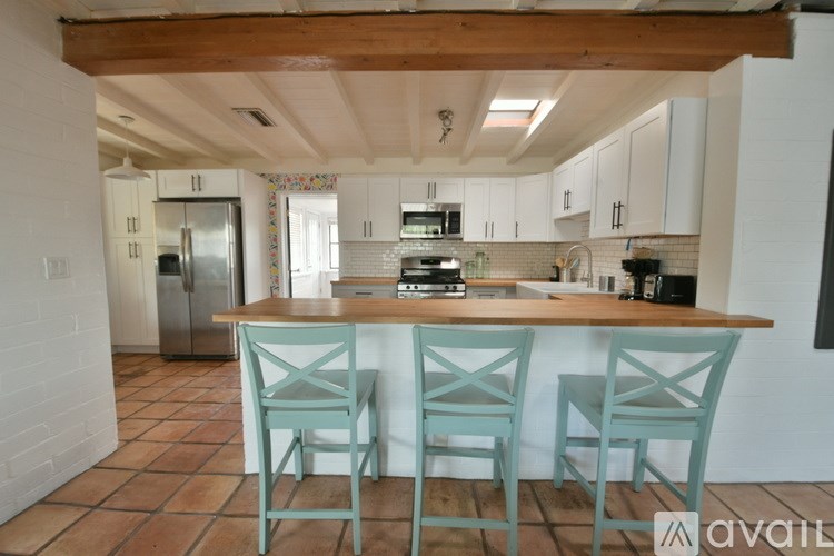 A kitchen with a table and chairs in front of it.