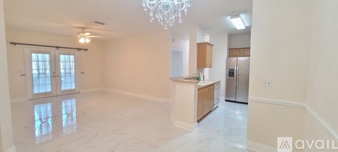 A spacious kitchen with a refrigerator, sink, and cabinets.
