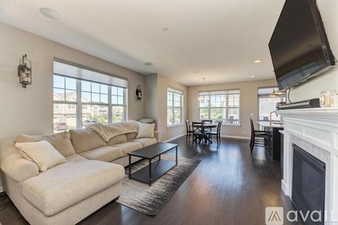 A living room with a white couch and a fireplace.