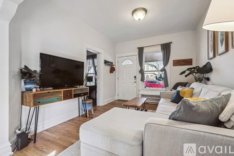 A living room with a white couch and a television on a wooden stand.