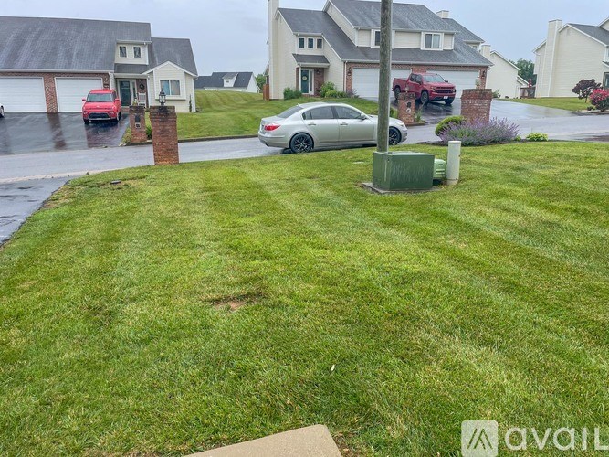 A silver car is parked on a driveway in front of a house.