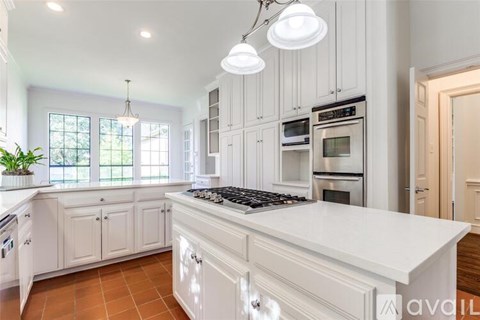 A kitchen with white cabinets and a large island.