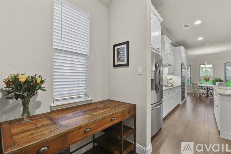 A kitchen with a wooden table and a vase of flowers on it.