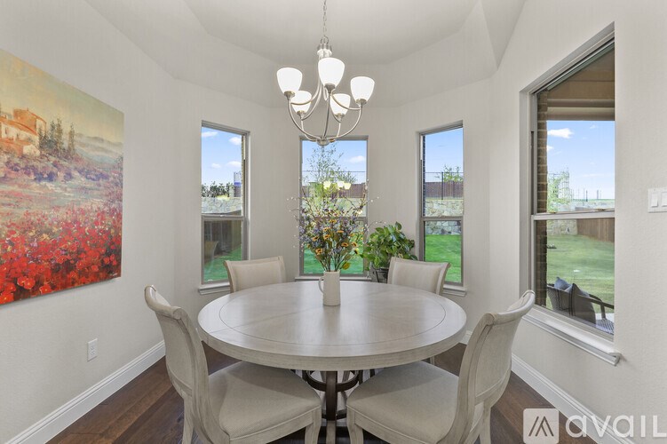 A dining room with a round table and chairs.