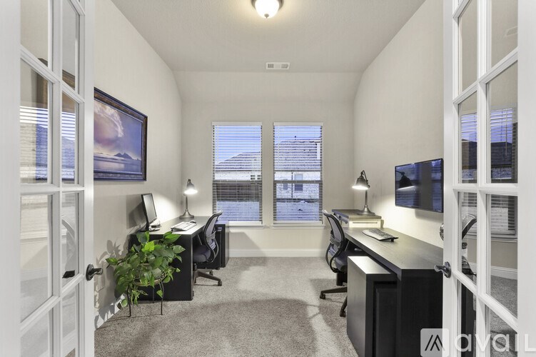 A well-lit office space with two desks and two chairs.