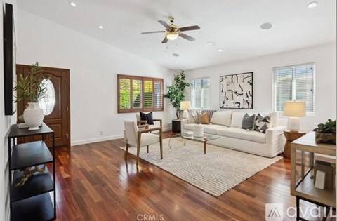 A living room with a white couch and a rug.