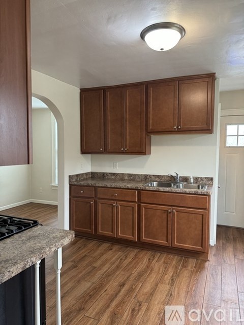 A kitchen with wooden cabinets and a granite countertop.